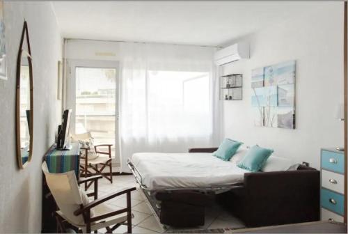 une chambre avec un lit et une chaise dedans dans l'établissement CANELLE- Beau 2p,tout confort, vue mer, piscine, à Antibes