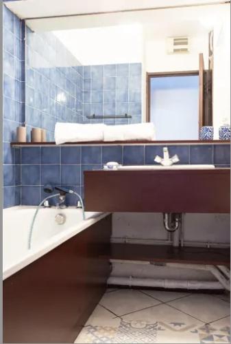 une salle de bain avec une baignoire, un lavabo et un miroir dans l'établissement CANELLE- Beau 2p,tout confort, vue mer, piscine, à Antibes