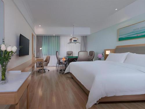 a hotel room with a bed and a dining room at Vienna Hotel Guangdong Foshan Shunde Longjiang Material City in Shunde