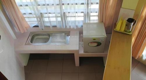 a small kitchen with a sink and a window at Sapadia Hotel Parapat in Parapat