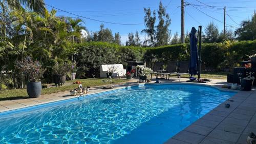 a large blue swimming pool in a yard at Grand logement 2 en 1 à Boucan Canot Plage in Saint-Gilles les Bains