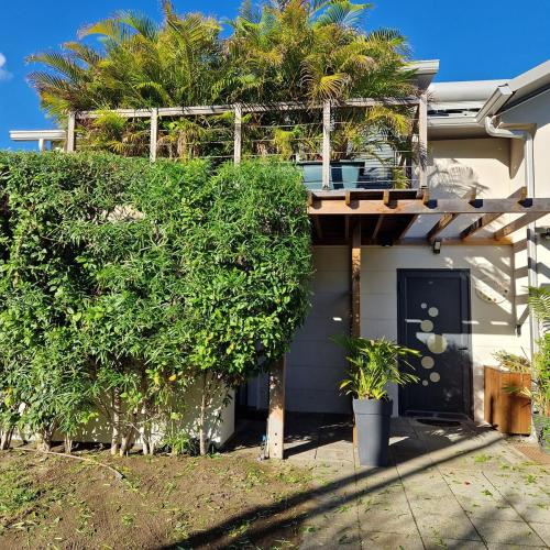 a house with a balcony with trees on it at Grand logement 2 en 1 à Boucan Canot Plage in Saint-Gilles les Bains