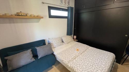 a blue couch with pillows in a room at Grand logement 2 en 1 à Boucan Canot Plage in Saint-Gilles les Bains