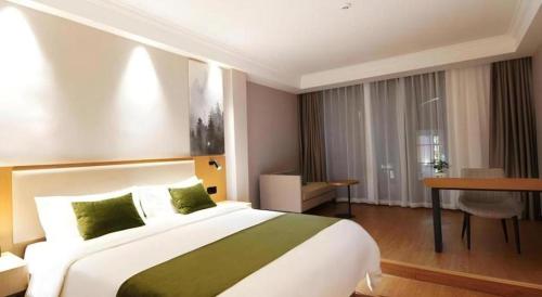 a hotel room with a large bed and a desk at GreenTree Inn Luoyang Henan University of Science and Technology in Luoyang