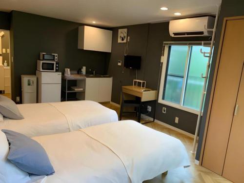 a hotel room with two beds and a kitchen at HOSTEL LUND I -Oimachi- in Tokyo