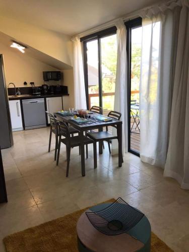 a kitchen and dining room with a table and chairs at Grand logement 2 en 1 à Boucan Canot Plage in Saint-Gilles les Bains
