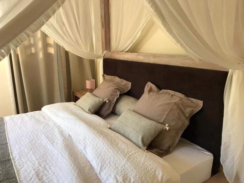 a bedroom with a white bed with pillows at Grand logement 2 en 1 à Boucan Canot Plage in Saint-Gilles les Bains
