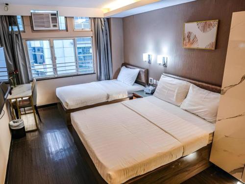 a hotel room with two beds and a window at Sunny Day Hotel in Hong Kong