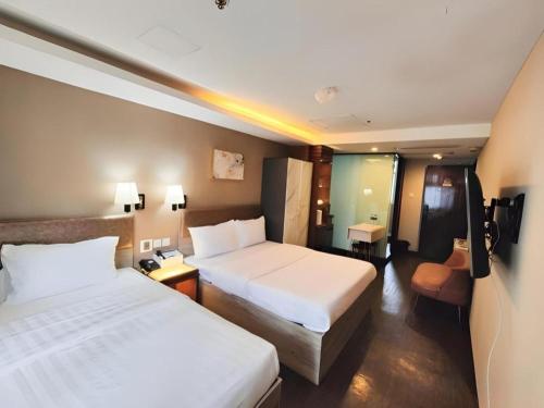 a hotel room with two beds and a television at Sunny Day Hotel in Hong Kong