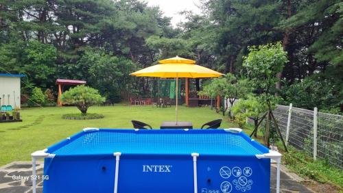 a table with an umbrella next to a pool at Bauhaus In Wonju in Wonju