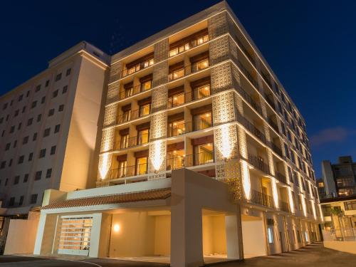 un edificio alto con luces encendidas por la noche en Community & Spa Naha Central Hotel, en Naha