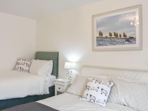 a bedroom with two beds and a picture on the wall at The Croft in Stanhope