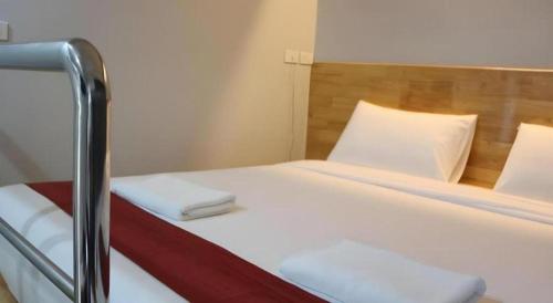 a bed in a room with two pillows on it at The Grace Residence in Surin