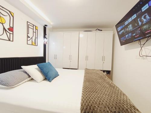 a bedroom with a large bed with white cabinets at Apt nuevo 15min CC BuenavistValmundo TV50 Netflix in Barranquilla