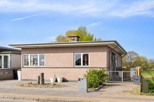 a small pink house with a fence in front of it at Sea And Meadow Views Space And Calm in Nyborg