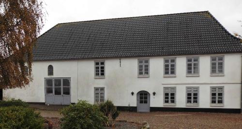 a white house with a black roof at Large Holiday Home Near Tønder in Tønder