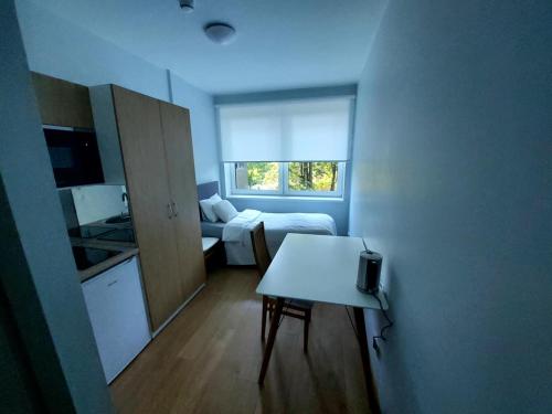 a small room with a bed and a table in it at Pepleri 34 mini studio apartment in Tartu