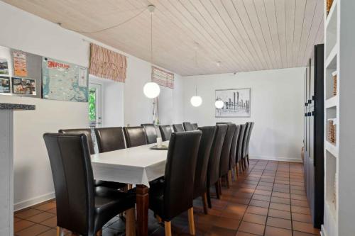 a dining room with a table and leather chairs at Large Holiday Home Near Tønder in Tønder