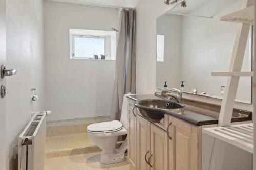 a white bathroom with a sink and a toilet at Large Holiday Home Near Tønder in Tønder