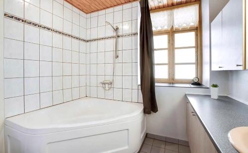 a white bathroom with a tub and a sink at Large Holiday Home Near Tønder in Tønder