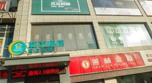 a building with signs on the side of it at City Comfort Inn Hotel Wuhan Optics Valley Square Metro Station Zhongnan Minzu University in Wuhan