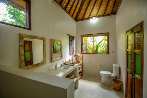a bathroom with a tub and a sink and a toilet at Aashaya Jasri Resort in Jasri
