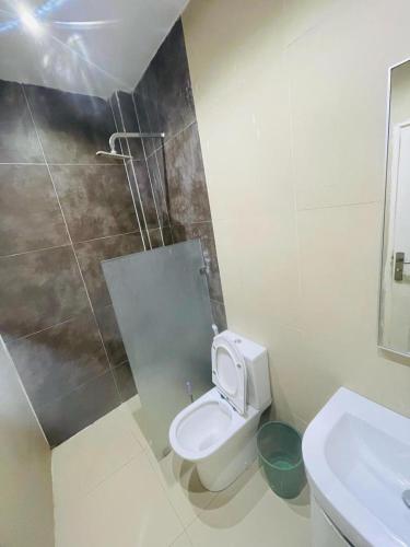 a white bathroom with a toilet and a sink at AF Logement in Dakan