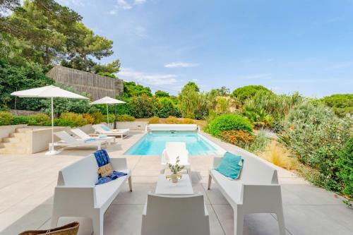 une terrasse avec une piscine et des chaises. dans l'établissement Villa Hedone - Presqu'île de Giens Piscine Vue mer, à Hyères