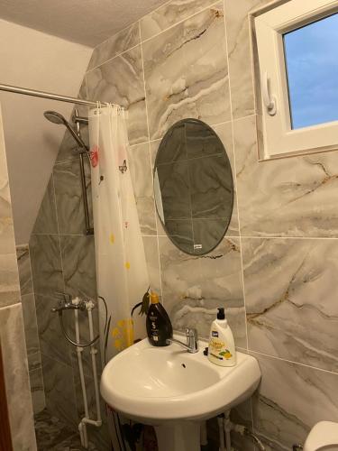 a bathroom with a sink and a mirror at Pensiunea Casa La Cabană Girov in Girov