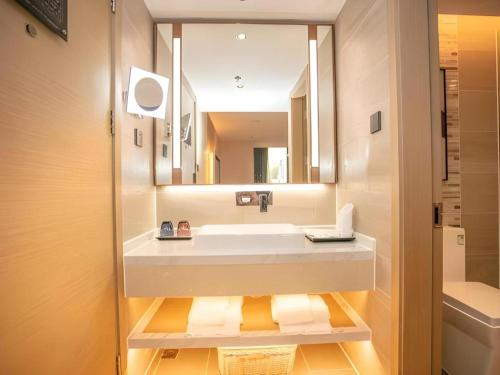 a bathroom with a sink and a mirror at Lavande Hotel Shenzhen East Gate Wanxiang City Guomao Metro Statipn in Shenzhen