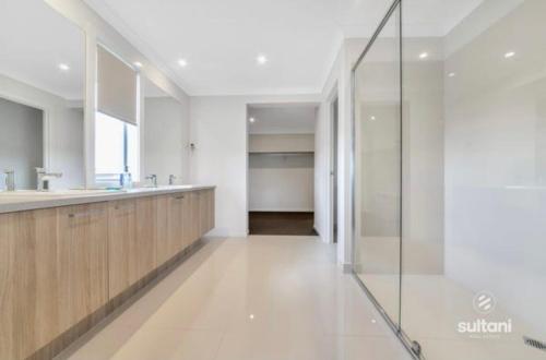 a bathroom with a sink and a glass shower at Exclusive Perfectly Big House by My Lodgingfy International in Clyde North
