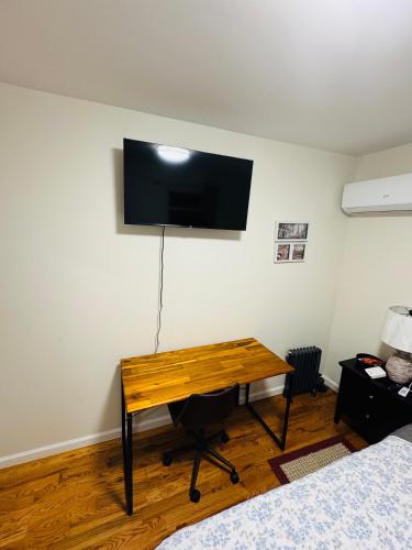 a room with a desk with a television on the wall at Guiding Light in Springfield Gardens