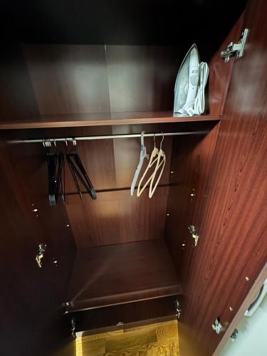 a wooden shelf with shoes and hangers on it at Guiding Light in Springfield Gardens