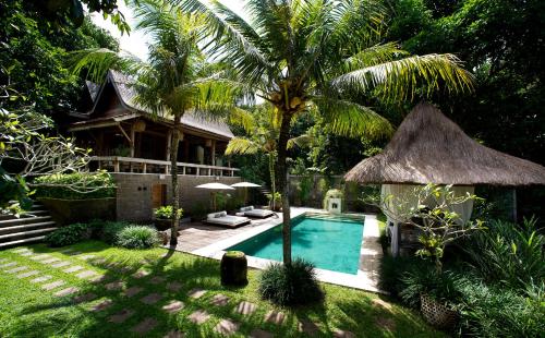 een achtertuin met een zwembad en een huis bij Kalapa Boutique Resort & Yoga in Canggu