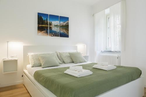 a white bedroom with a large bed with two trays on it at Respiro del Lago in Ossuccio