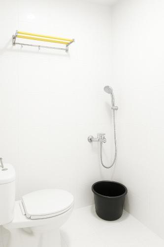 a white bathroom with a shower and a toilet at Hotel Madiyara in Mukomuko