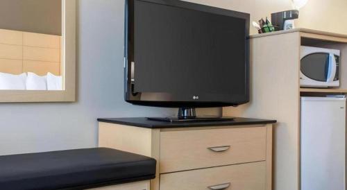 a flat screen tv sitting on top of a dresser at Quality Inn in Geneseo
