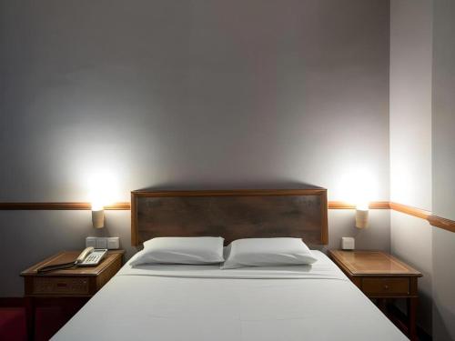a bedroom with a large bed with two night stands at Four Chain View Hotel in Singapore