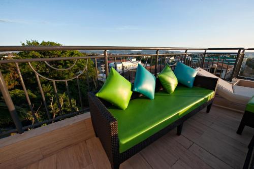 a green bench with four pillows on a balcony at Lime Hotel Boracay in Boracay