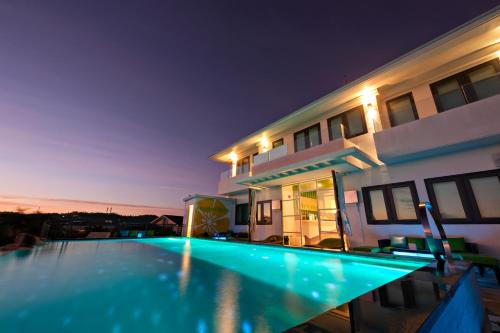 a swimming pool in front of a house at night at Lime Hotel Boracay in Boracay