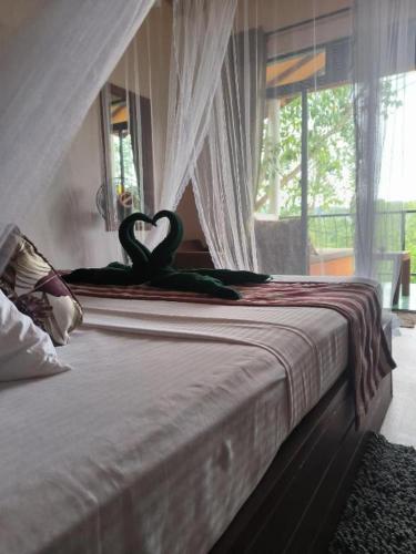 two swans in the shape of a heart sitting on a bed at White Elephant Ella in Ella