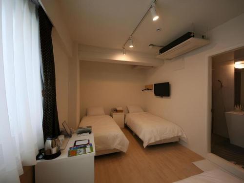 um quarto com duas camas, uma mesa e uma janela em Wons Ville Myeongdong Hotel em Seul