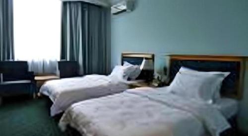 two beds in a hotel room with white sheets at Traders Inn Brunei in Bandar Seri Begawan