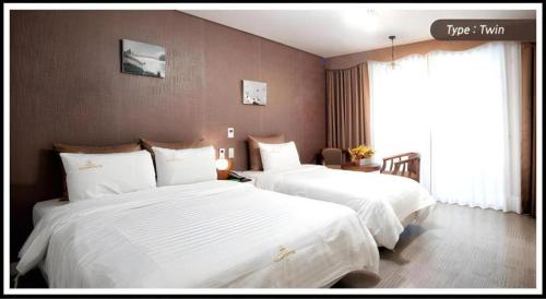 a hotel room with two beds and a window at BENIKEA Technovalley Hotel in Daejeon