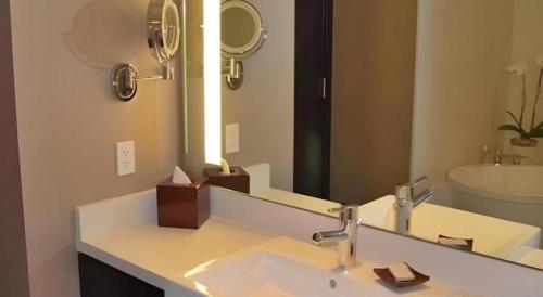 a bathroom with a sink and a large mirror at Luxury Suites International by Vdara in Las Vegas