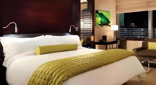 a bedroom with a large bed with a green blanket at Luxury Suites International by Vdara in Las Vegas