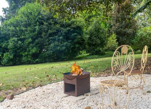 a fire pit and two chairs in a yard at Family-Friendly Hinterland Stay l Nova Escapes in Dorroughby
