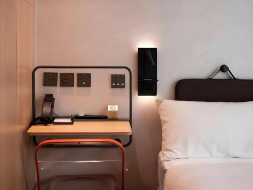 a bedroom with a desk next to a bed at Harbour Bay Hotel in Hong Kong
