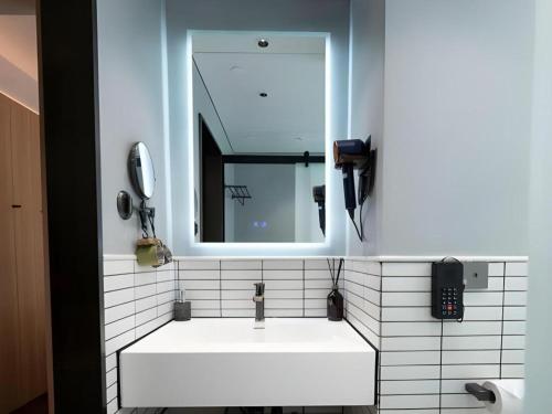 a bathroom with a white sink and a mirror at Harbour Bay Hotel in Hong Kong