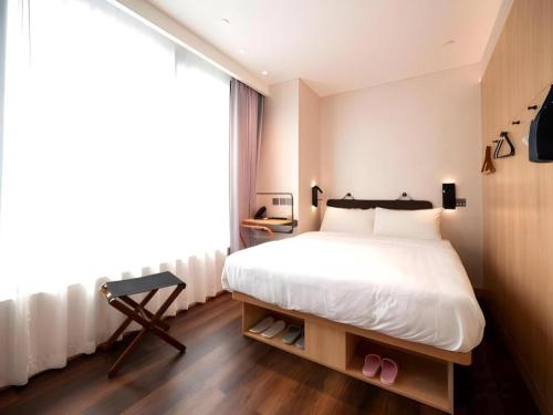 a bedroom with a large white bed and a window at Harbour Bay Hotel in Hong Kong